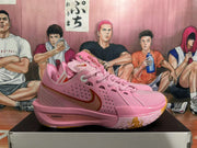 Side view of a pink Nike basketball shoe with gold-toned Swoosh and ZoomX text