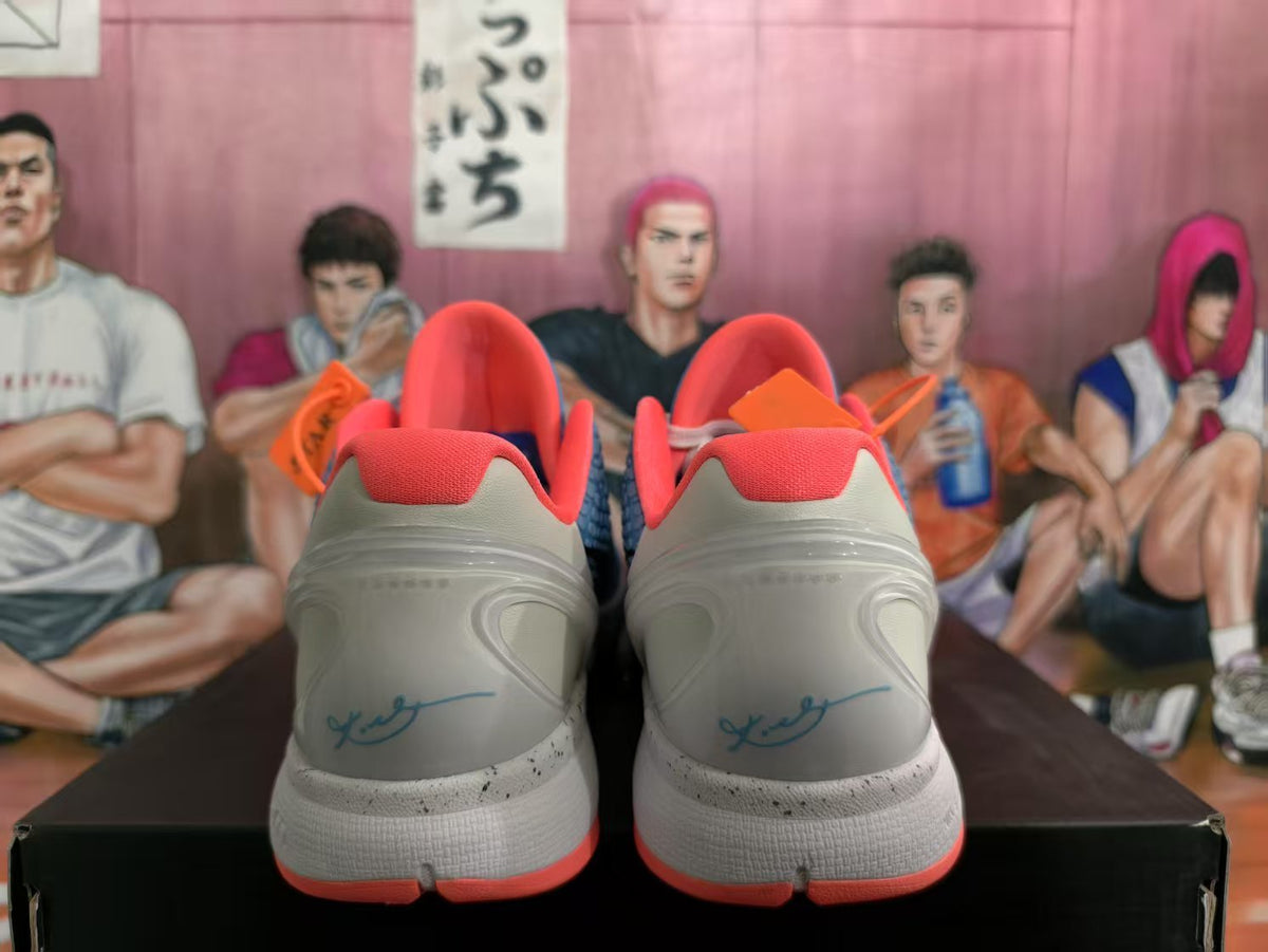 Rear view of blue, white, and orange Nike Zoom basketball sneakers showing orange collars, white heels, and speckled midsoles.