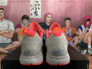 Rear view of blue, white, and orange Nike Zoom basketball sneakers showing orange collars, white heels, and speckled midsoles.