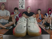 Front view of white Nike basketball sneakers showing white laces, black Swoosh details, and pink side accents.