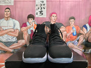 Front view of black high-top basketball shoes with white soles and lace-up fronts.