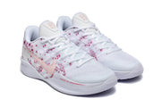 Pair of white low-top basketball shoes with pink floral print and pale pink Swooshes.