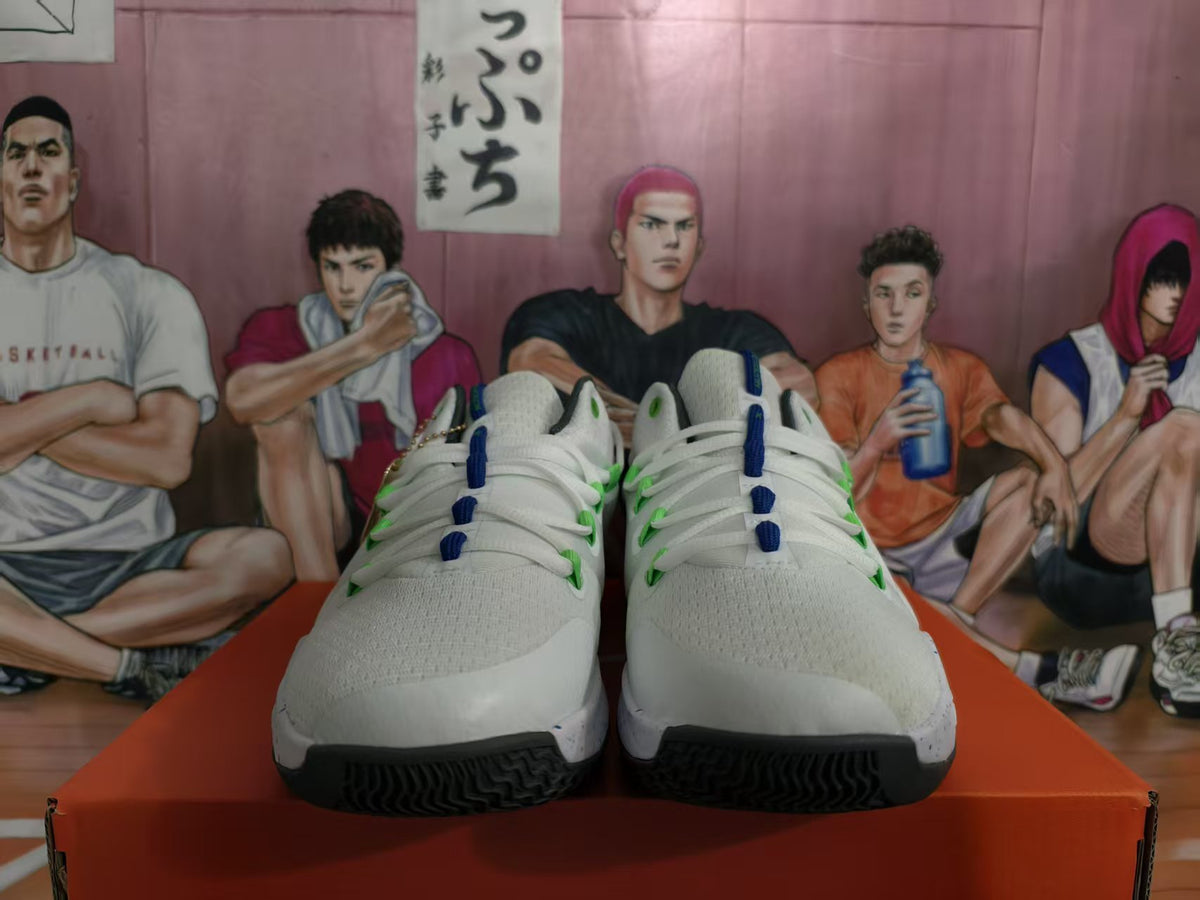 Front view of white Nike basketball shoes with green and blue accents