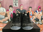 Front view of black Nike basketball sneakers with a repeating gray Swoosh pattern and translucent speckled soles.