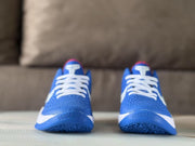 Front view of the pair showing white laces, blue textured toe boxes, and red-accented tongues.