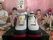 Front view of the pair showing white laces, padded ankle straps, navy toe panels, and red outsole sections.