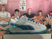 Side view of gray Puma low-top sneakers with a dark blue stripe