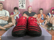 Front view of the red and black sneakers showing the laces, textured toe panels, and tongue logos.