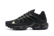 Side profile of a black Nike Air Max Plus sneaker with lime lace loops