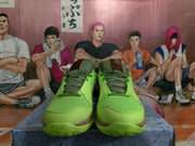Front view of bright green Nike basketball sneakers with olive laces, mesh uppers, and brown trim.