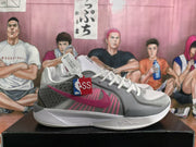 Side profile highlighting the Nike swoosh, layered gray panels, pink detailing, and white midsole.