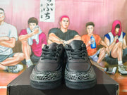 Front view of black lace-up sneakers with grey-and-black patterned toe overlays.