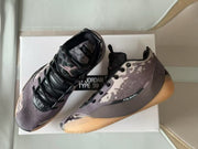 Pair of Air Jordan 39 sneakers with black laces, patterned mauve-gray uppers, and the shoebox behind them.