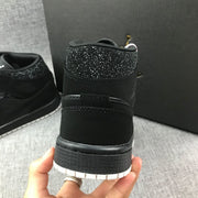 Close-up of the rear heel, pull tab and textured black midsole with a white outsole.