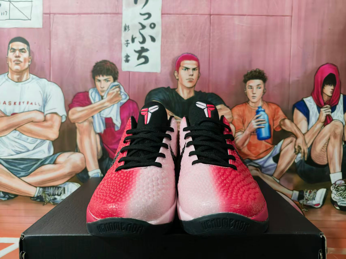 Front view of pink and black basketball sneakers displayed on a black box