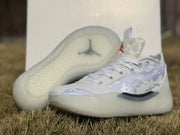 White Jordan 39 sneakers shown with one outsole facing upward