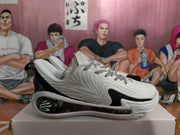 Side profile of a white and black basketball sneaker with a textured upper and sculpted sole.