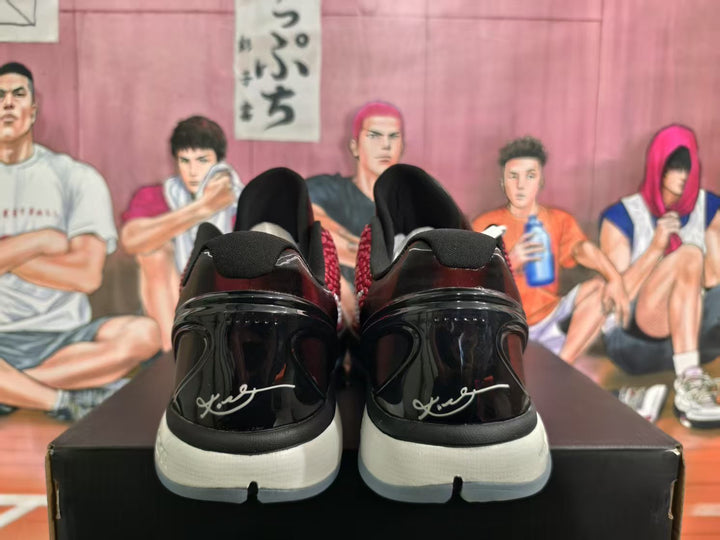 Rear view of black and red Nike LeBron sneakers showing glossy heel panels, black collars, and white midsole sections.