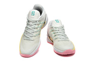 Pair of pale Nike Kobe basketball shoes shown from the front, with turquoise tongue details and pink and yellow sole accents.