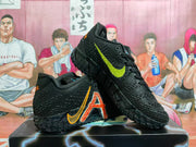 Pair of black Nike basketball shoes with textured uppers, orange and lime side graphics, and patterned outsoles.