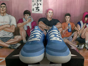 Front view of a pair of blue basketball sneakers with white laces and light-colored outsoles.