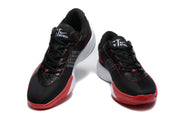 Pair of black Nike basketball shoes with red outsoles, white midsoles, and red-trimmed side Swooshes shown from the front.