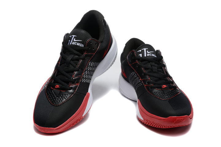 Pair of black Nike basketball shoes with red outsoles, white midsoles, and red-trimmed side Swooshes shown from the front.