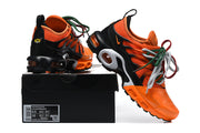Orange and black Nike Air Max Plus sneakers displayed on a shoe box with its size label visible.