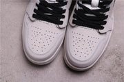 Close-up of the perforated light-colored toe boxes and black laces.