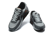 Pair of grey and black Nike Air Max 90 sneakers viewed from above and the front.