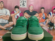 Front view of green Jordan low-top sneakers with tonal laces, tongue logos, white midsoles, and red outsole accents.