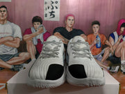 Front view of the white and black sneakers showing black toe panels, textured uppers, and patterned laces.