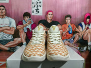 Front view of Nike KD basketball shoes with cream laces, KD tongue logos, and a khaki horse-pattern upper.