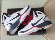 Pair of white high-top basketball shoes with black and red accents on a box