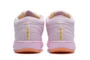 Rear view of the pink sneakers showing padded collars, gold heel lettering, and orange outsole sections.