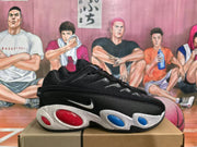 Side view of a black Nike sneaker showing the swoosh, textured upper, white speckled midsole and red and blue oval details.
