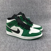 Three-quarter view of the pair with black tongues, green overlays, and white toe panels.