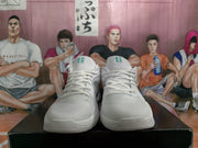 Front view of the white Nike basketball sneakers showing the lace-up construction, tongue accents, and textured toe areas.