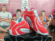 Angled side view of red basketball shoes with light blue and white accents