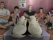 Front view of cream Nike basketball shoes with perforated toe areas and cream laces.
