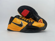 Pair of orange-and-black low-top shoes shown from the side, with one outsole visible.