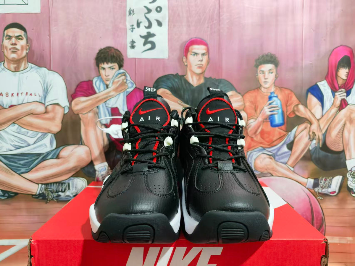 Front view of black Nike sneakers with red accents, white midsoles, and AIR lettering on the tongues.