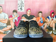Front view of black and gold Nike Kobe basketball shoes with translucent blue-toned soles