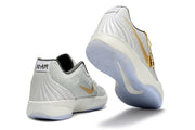 Light gray Nike Ja 2 shoes with gold accents shown from rear and outsole angles