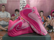 Angled view of the pink Nike basketball shoes showing the side detailing, swoosh, and layered outsole.