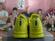 Rear view showing the yellow heel panels, padded collars, and blue heel branding details.