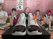 Front view of the sneakers showing black toe panels, white laces, and Kobe-inspired tongue logos.