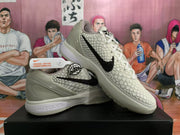 Angled view of paired white Nike basketball shoes showing the textured upper, black Swoosh, star detailing, and sculpted midsoles.