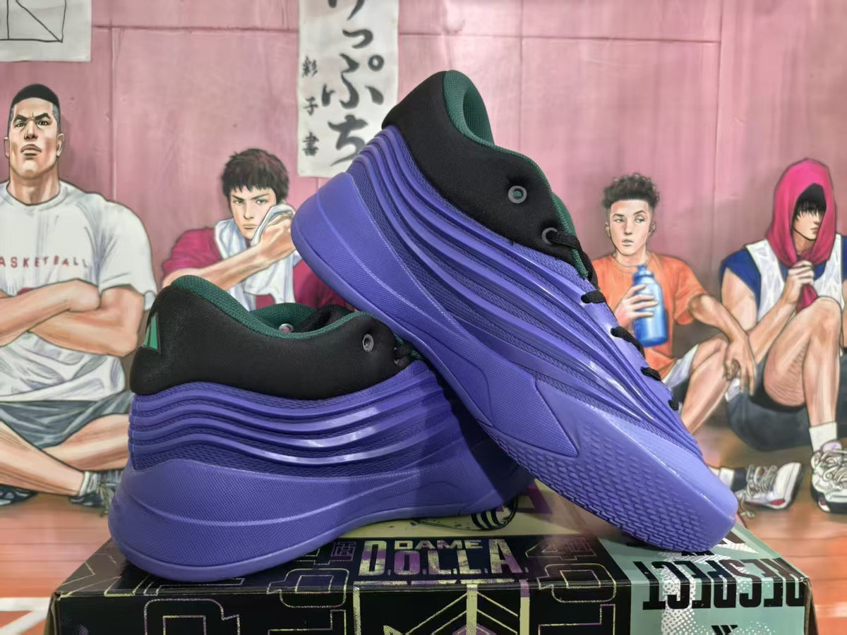 Pair of black and blue adidas basketball sneakers shown from the side and rear on a shoebox.