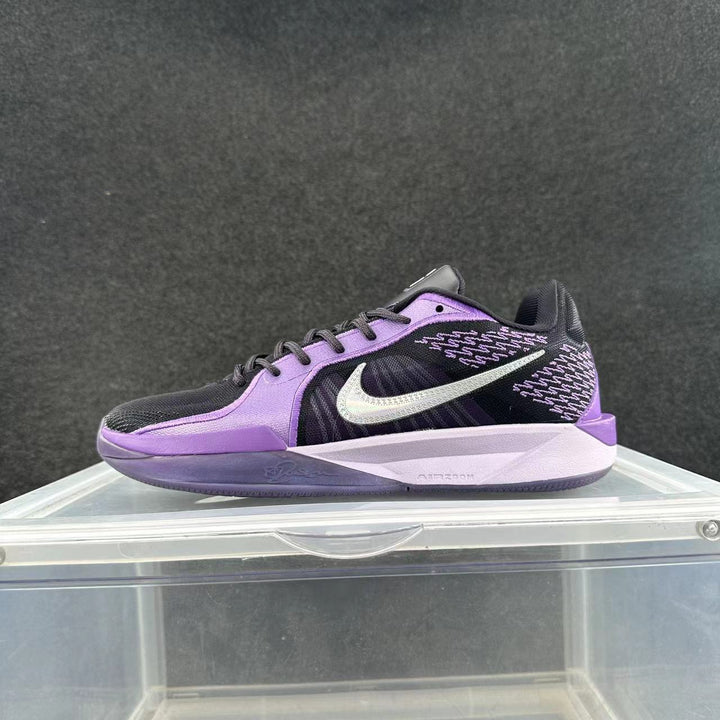 Side view of a purple and black Nike sneaker with a visible Swoosh logo, patterned upper details, and a light-colored Air Zoom-marked midsole.